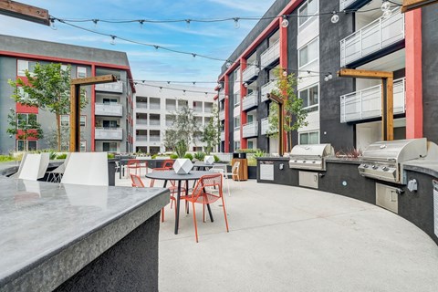 A patio with a table and chairs is surrounded by apartment buildings.